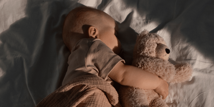 Bebê dormindo com urso de pelúcia
