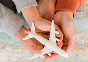 mãos segurando um avião