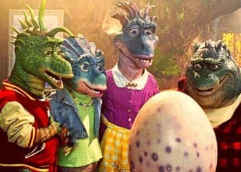 Personagens de Família Dinossauros olhando para um ovo.