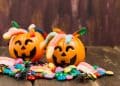 Dois baldes de abóbora com doces dentrp, representando a alergia alimentar no Halloween.