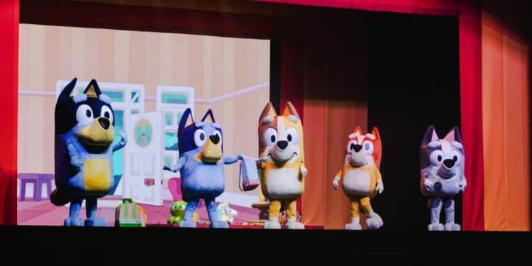 Personagens da série Bluey no palco de um teatro.