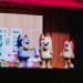 Personagens da série Bluey no palco de um teatro.
