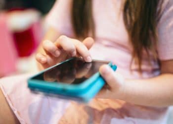 Menina usando um celular.