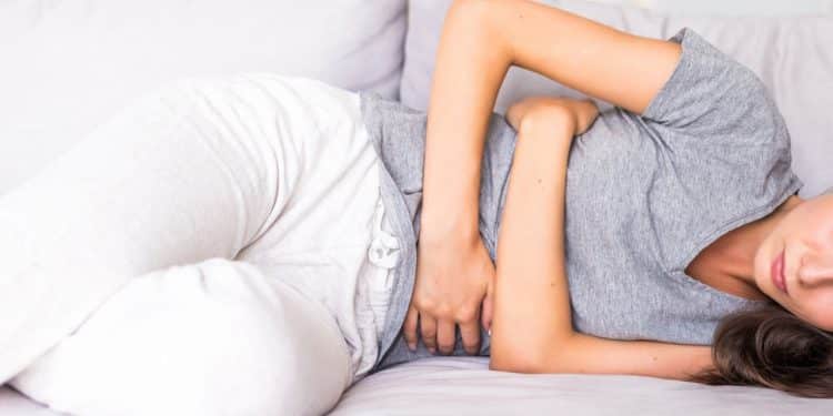 Mulher deitada com constipação pós-parto.