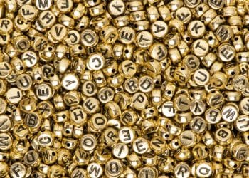 Miçangas douradas representando nomes de bebê.