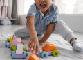 Criança sorrindo brincando c seus brinquedos