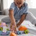 Criança sorrindo brincando c seus brinquedos