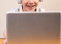 Criança olhando para o computador e sorrindo