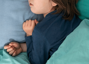 Crinaça dormindo, deitada em um lençol azul