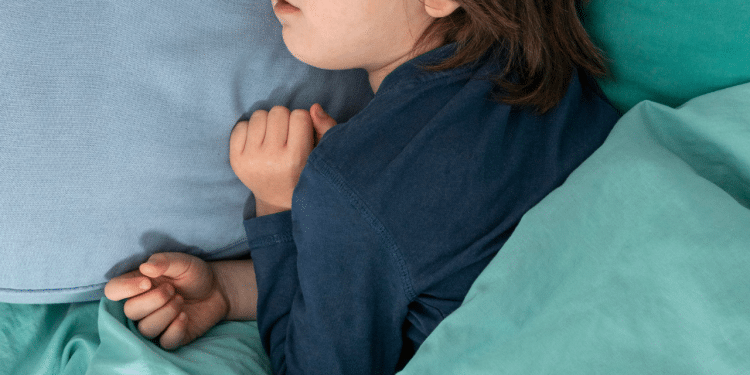 Crinaça dormindo, deitada em um lençol azul