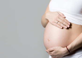 Mulher grávida com a mão na barriga