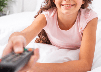 Criança segurando um controle na mão e sorrindo