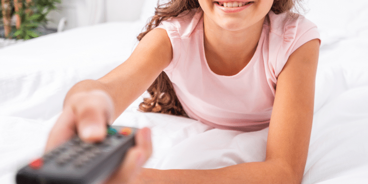 Criança segurando um controle na mão e sorrindo