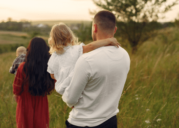 Uma mulher, um homem e duas crianças em um campo