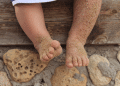 Pés de bebe sujo de areia