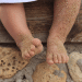 Pés de bebe sujo de areia