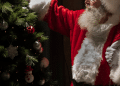 Papael Noel ao lado de uma árvore de natal