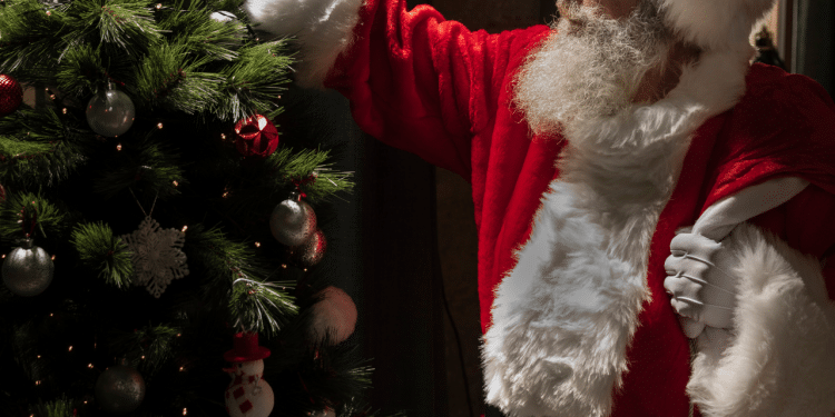 Papael Noel ao lado de uma árvore de natal