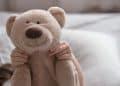 Criança com urso de pelúcia representando a parentalidade intensiva.