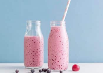 Smoothies de frutas vermelhas em frente a um fundo azul.