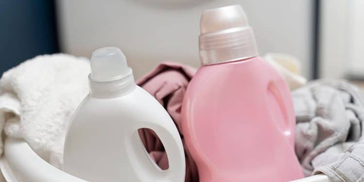 Amaciante de roupa em embalagem branca e rosa dentro de uma bacia.