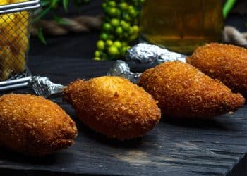 Quibe de carne com ingredientes em volta.