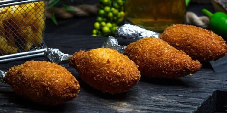 Quibe de carne com ingredientes em volta.