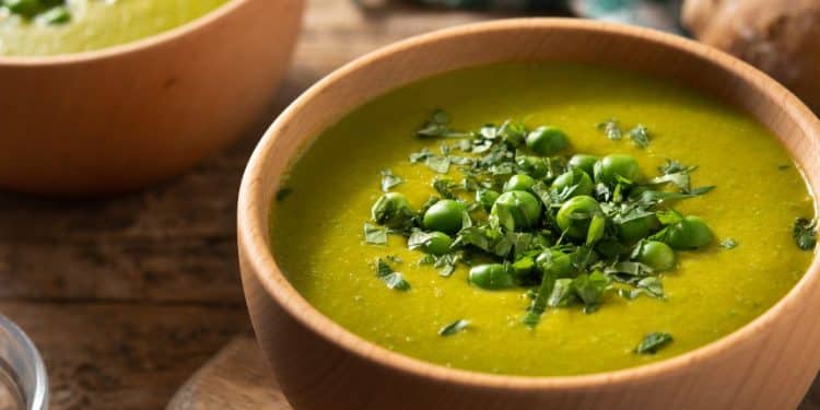 Sopa de ervilha em uma tigela marrom.