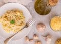 Prato de macarrão ao alho e óleo com ingredientes em volta.