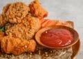 Frango frito com uma porção de ketchup ao lado.