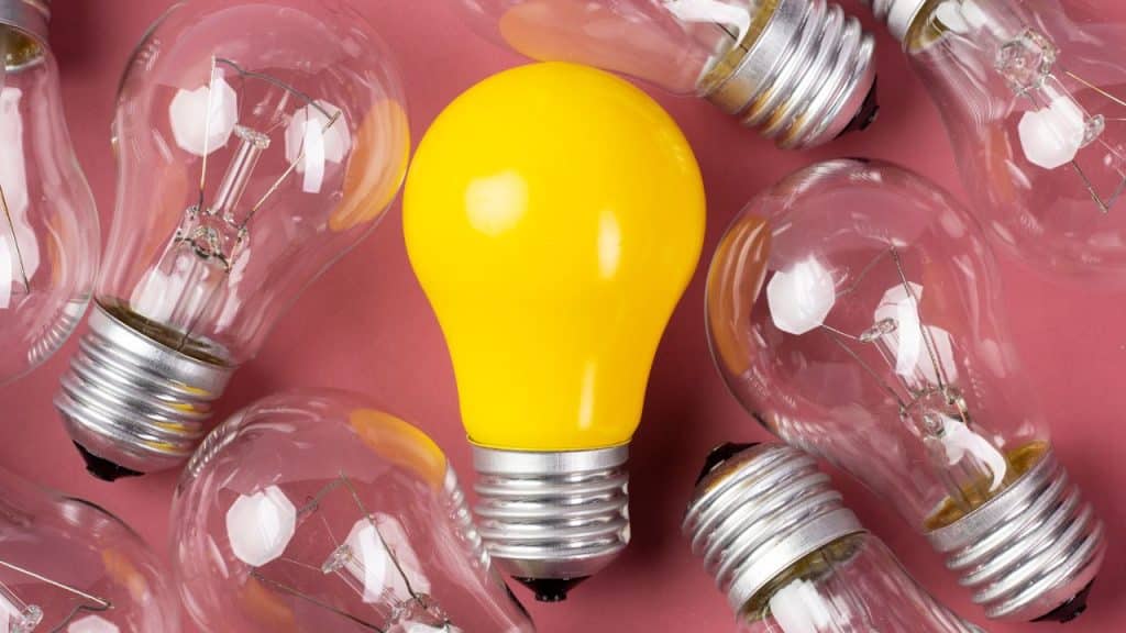 Lâmpada colorida no meio de lâmpadas transparentes representando João Vítor.