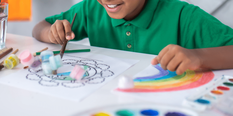 Criança sorrindo e desenhando