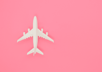 Imagem de uma miniatura de avião em um fundo rosa