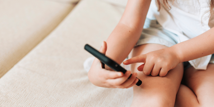 Mão de criança mexendo no celular