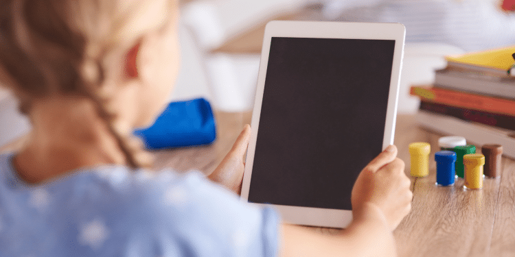 Criança com tablet na mão representando o uso de IA com crianças