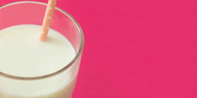 Copo de leite em um fundo rosa.