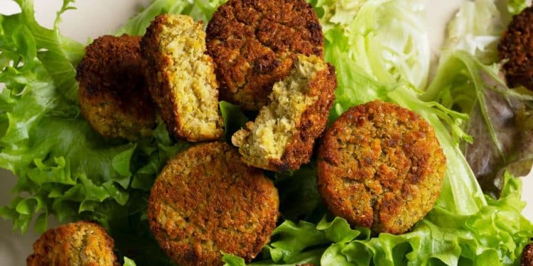 Bolinho de grão-de-bico em cima de alface.