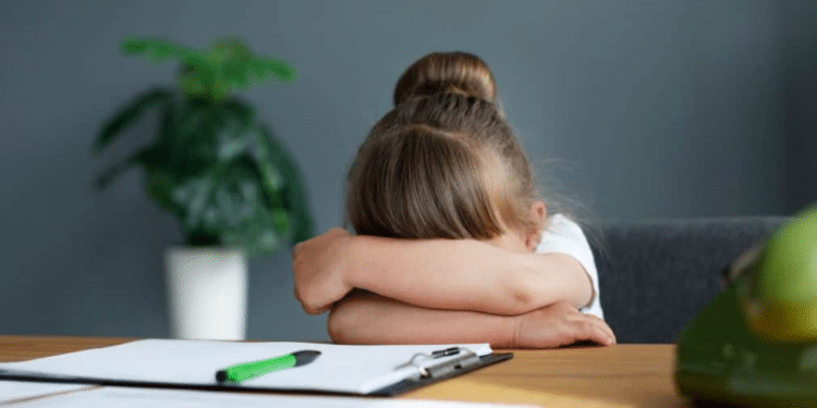 Criança com a cabeça baixa, chateada