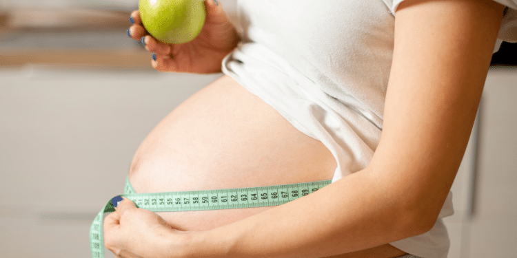 Mulher grávida medindo a barriga