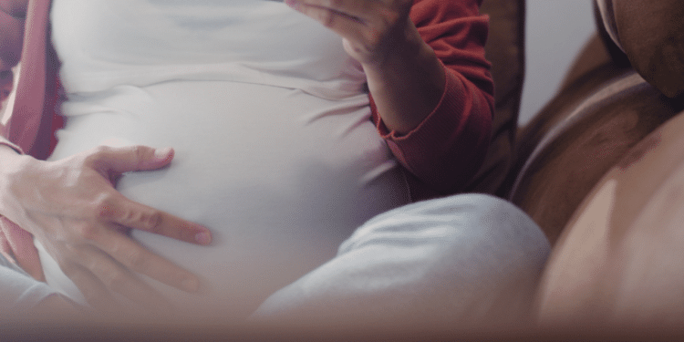 Grávida com a mão na barriga