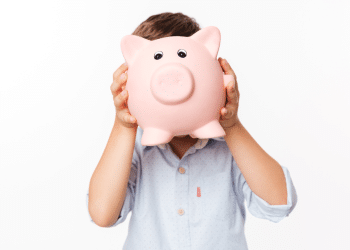 Criança segurando um cofrinho em forma de porco